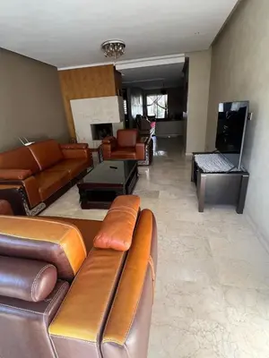 a living room with leather couches and a couch at Prestigia luxury home in Fès