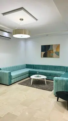 a living room with a green couch and a table at luxury Apartment Near Stadium and Airport in Fès