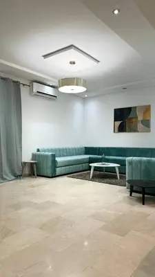 a living room with a green couch and a table at luxury Apartment Near Stadium and Airport in Fès