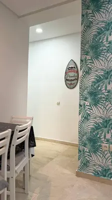 a room with a table and chairs and a wall at luxury Apartment Near Stadium and Airport in Fès
