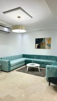 a living room with a green couch and a table at luxury Apartment Near Stadium and Airport in Fès
