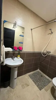 a bathroom with a sink and a shower with a mirror at luxury Apartment Near Stadium and Airport in Fès