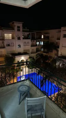 a view of a building at night with a table and chairs at luxury Apartment Near Stadium and Airport in Fès