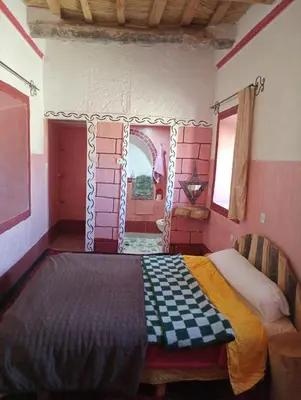 a bedroom with a bed in a room with a mirror at Dar Laayoune in Kalaat MGouna