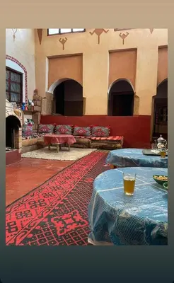 a living room with two tables and a rug at Dar Laayoune in Kalaat MGouna