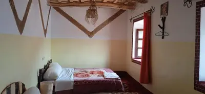 a bedroom with a bed in the corner of a room at Dar Laayoune in Kalaat MGouna