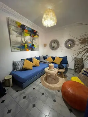 a living room with a blue couch and a table at La kasbah bleue in Marrakech