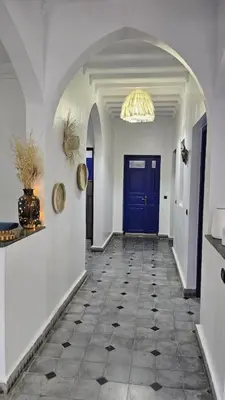 a hallway with a blue door and a tile floor at La kasbah bleue in Marrakech