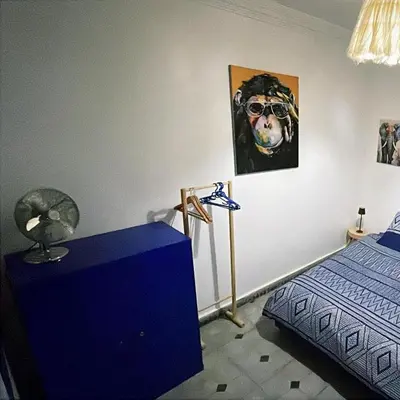 a bedroom with a bed and a painting of a dog at La kasbah bleue in Marrakech