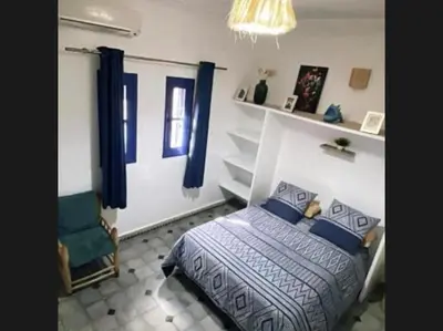 a bedroom with a bed and a chair at La kasbah bleue in Marrakech