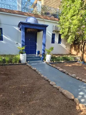 a pathway leading to a building with a blue door at La kasbah bleue in Marrakech