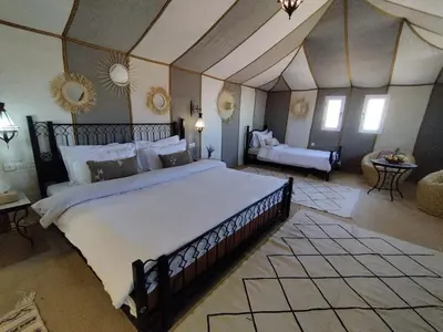 a bedroom with a large bed in a room at Luxury Nomadic Tented Camp in Merzouga