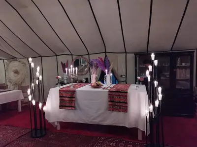 a table in a tent with lights on it at Luxury Nomadic Tented Camp in Merzouga
