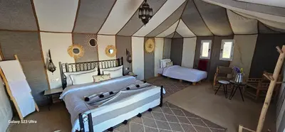 a bedroom with two beds in a room at Luxury Nomadic Tented Camp in Merzouga
