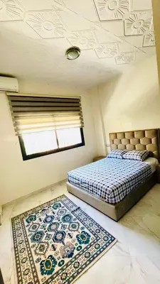a bedroom with a bed and a rug and a window at welcome to fez in Fès