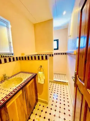 a bathroom with a sink and a mirror at Villa1 des tortues Marrakech in Aït Zat