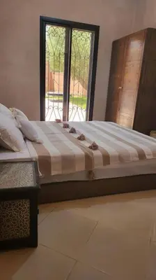 a large bed in a room with a window at Villa1 des tortues Marrakech in Aït Zat