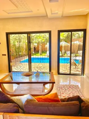 a living room with a couch and a glass table at Villa1 des tortues Marrakech in Aït Zat