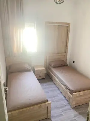 two twin beds in a room with a window at طريق صفرو in Fès