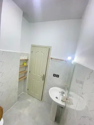 a white bathroom with a sink and a door at طريق صفرو in Fès