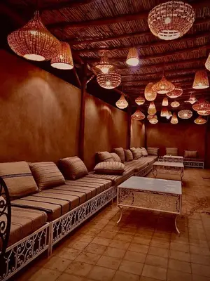 a room with a large couch and many chandeliers at Dar Diafa in Merzouga