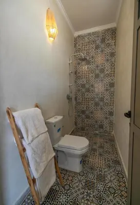 a bathroom with a toilet and a towel on a chair at Dar Diafa in Merzouga