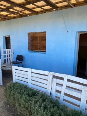 a blue house with a white fence and a window at Les cavaliers chez Yassine in Marrakech