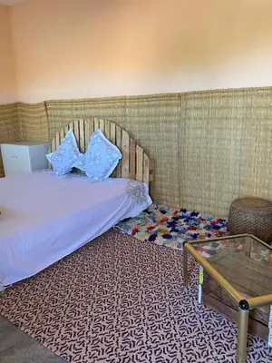 a bedroom with a bed and a glass table at Les cavaliers chez Yassine in Marrakech