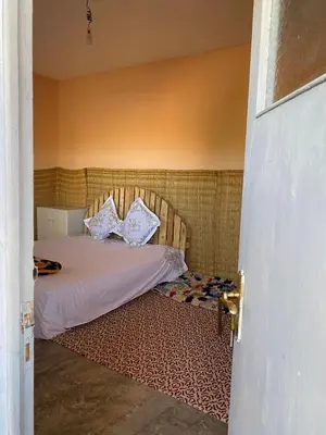 a bedroom with a bed with white sheets and pillows at Les cavaliers chez Yassine in Marrakech