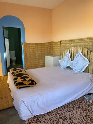 a bed with pillows on it in a bedroom at Les cavaliers chez Yassine in Marrakech