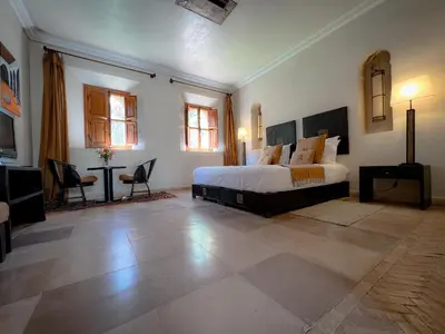 a large bedroom with a bed and a table at Maidan El Arsa in Marrakech