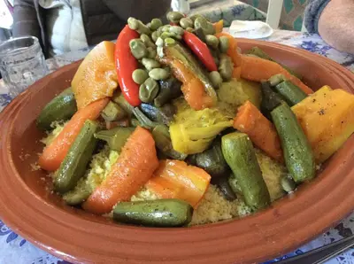 a bowl of vegetables on a plate on a table at Maidan El Arsa in Marrakech