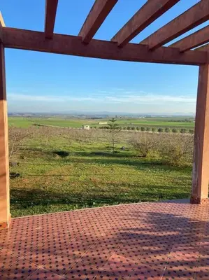 a view of a field from a screened in porch at belle ferme a louer in Tiflet