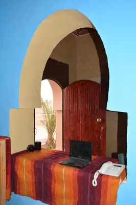 a laptop computer sitting on top of a bed at Sahara House in Merzouga
