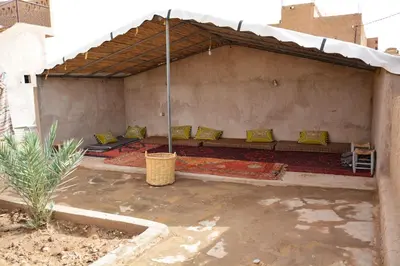 a patio with a couch with yellow pillows at Sahara House in Merzouga