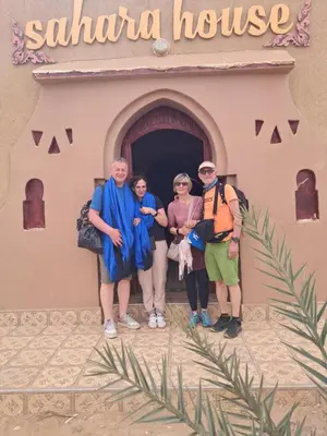 a group of people standing in front of a building at Sahara House in Merzouga