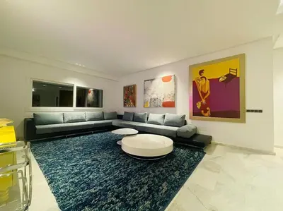 a living room with a couch and a rug at Appartement spacieux et luxueux in Fès