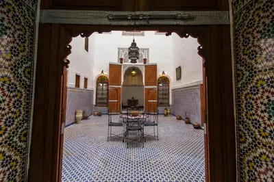 a hallway with a table and chairs in a building at Dar Nejma in Fès