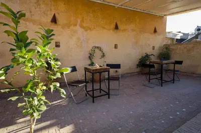a patio with two tables and chairs and plants at Dar Nejma in Fès