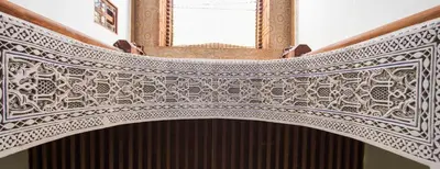 a close up of an ornate whiteintel with a window at Dar Nejma in Fès