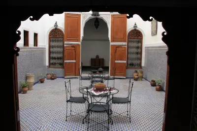 a courtyard with a table and chairs in a building at Dar Nejma in Fès