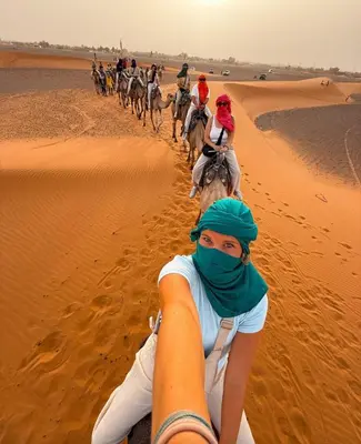 a group of people riding horses in the desert at Perfect Luxury Camp in Merzouga