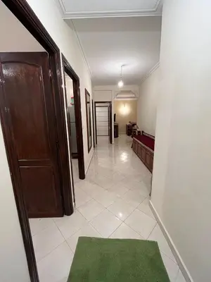 a hallway with a door and a green rug at Meknes Apartment Oudi in Meknès