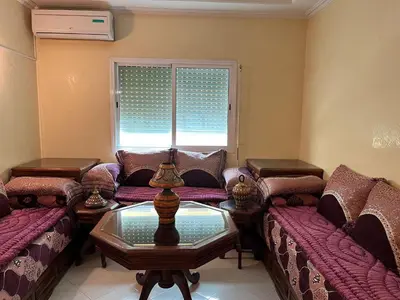 a living room with couches and a table and a window at Meknes Apartment Oudi in Meknès