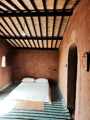 a bedroom with a bed in a brick wall at Silent Camp in Mhamid