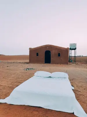a bed in the middle of the desert at Silent Camp in Mhamid