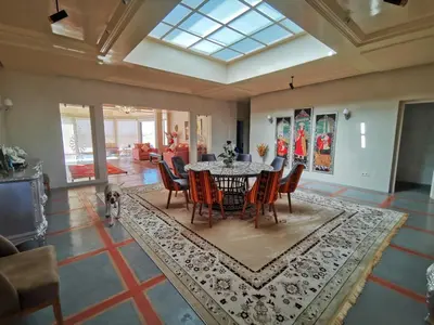 a dining room with a table and chairs on a rug at Domaine Lamrah in Marrakech