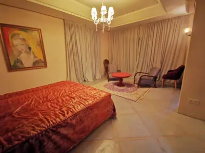 a bedroom with a bed and a table and chairs at Domaine Lamrah in Marrakech