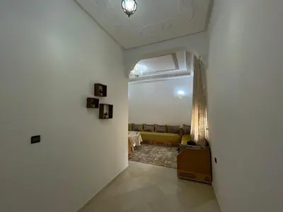 a hallway with a living room with a yellow couch at appartement meublee a louer sur Fes in Fès