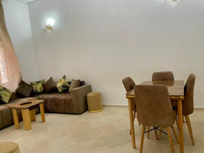 a living room with a couch and a table and chairs at appartement meublee a louer sur Fes in Fès